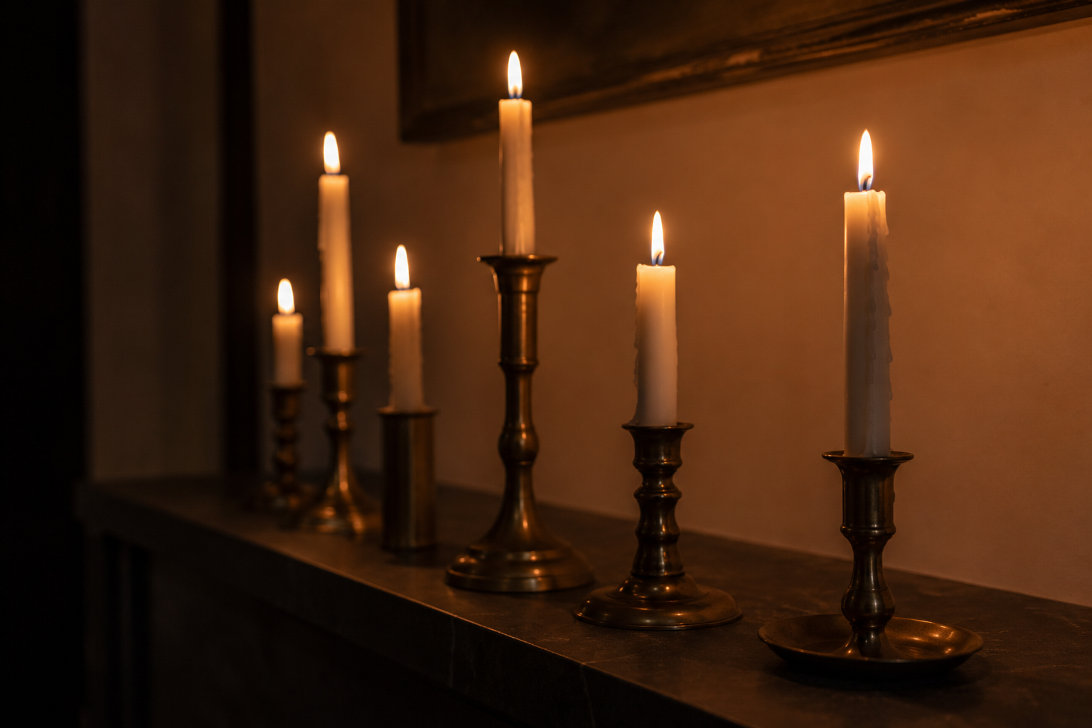 Taper candles lit down a table at dusk