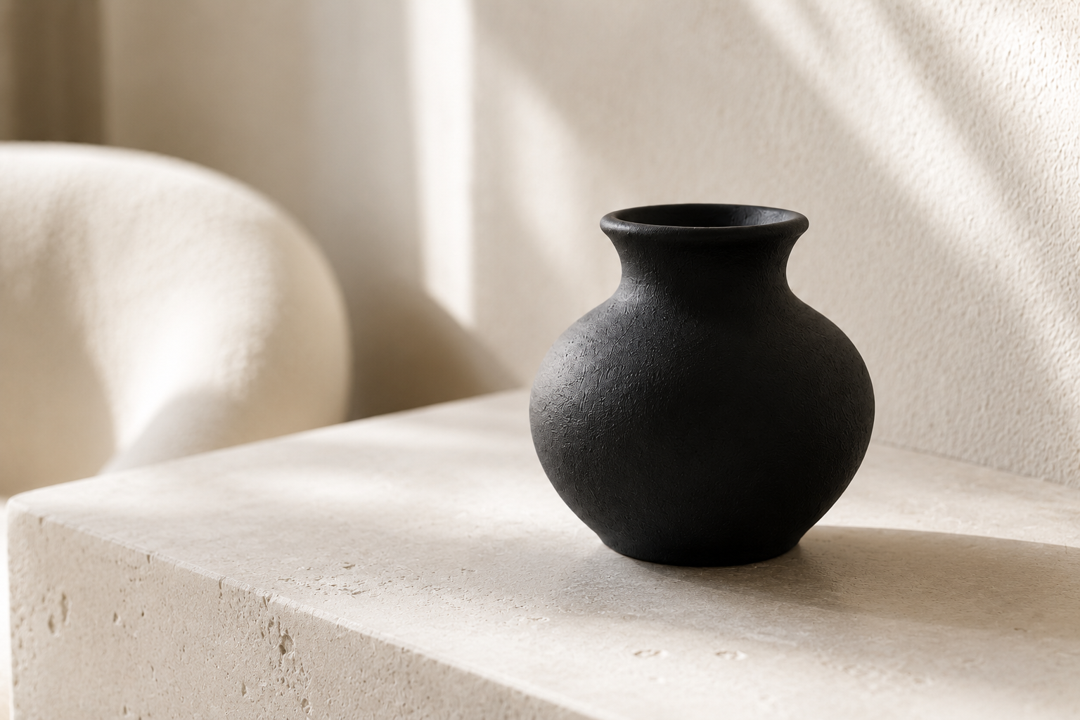 Matte black vase styled on a neutral console
