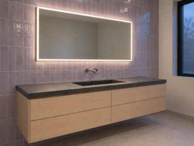 A frameless LED mirror casting an even band of light over a maple vanity against glossy lilac tile.