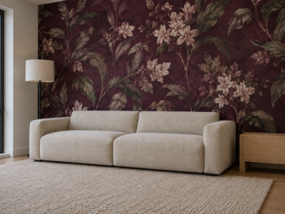 A living room accent wall covered in deep plum botanical peel-and-stick wallpaper behind a linen sofa.