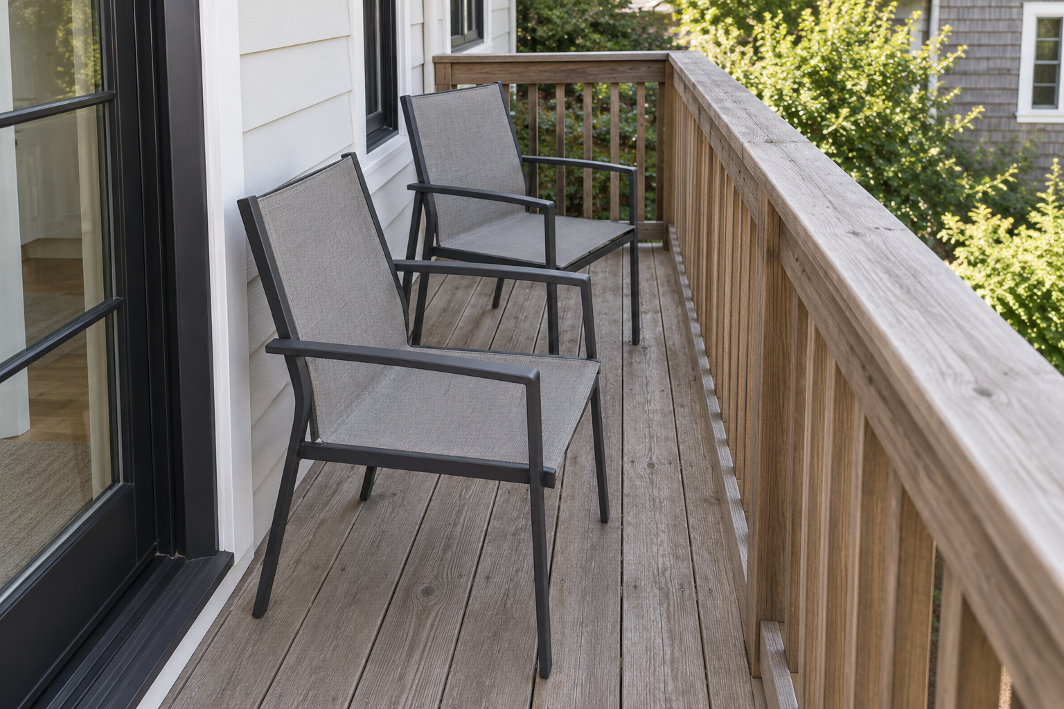 An elevated view of a narrow deck showing a genuinely tight walking gap between a chair and the railing.
