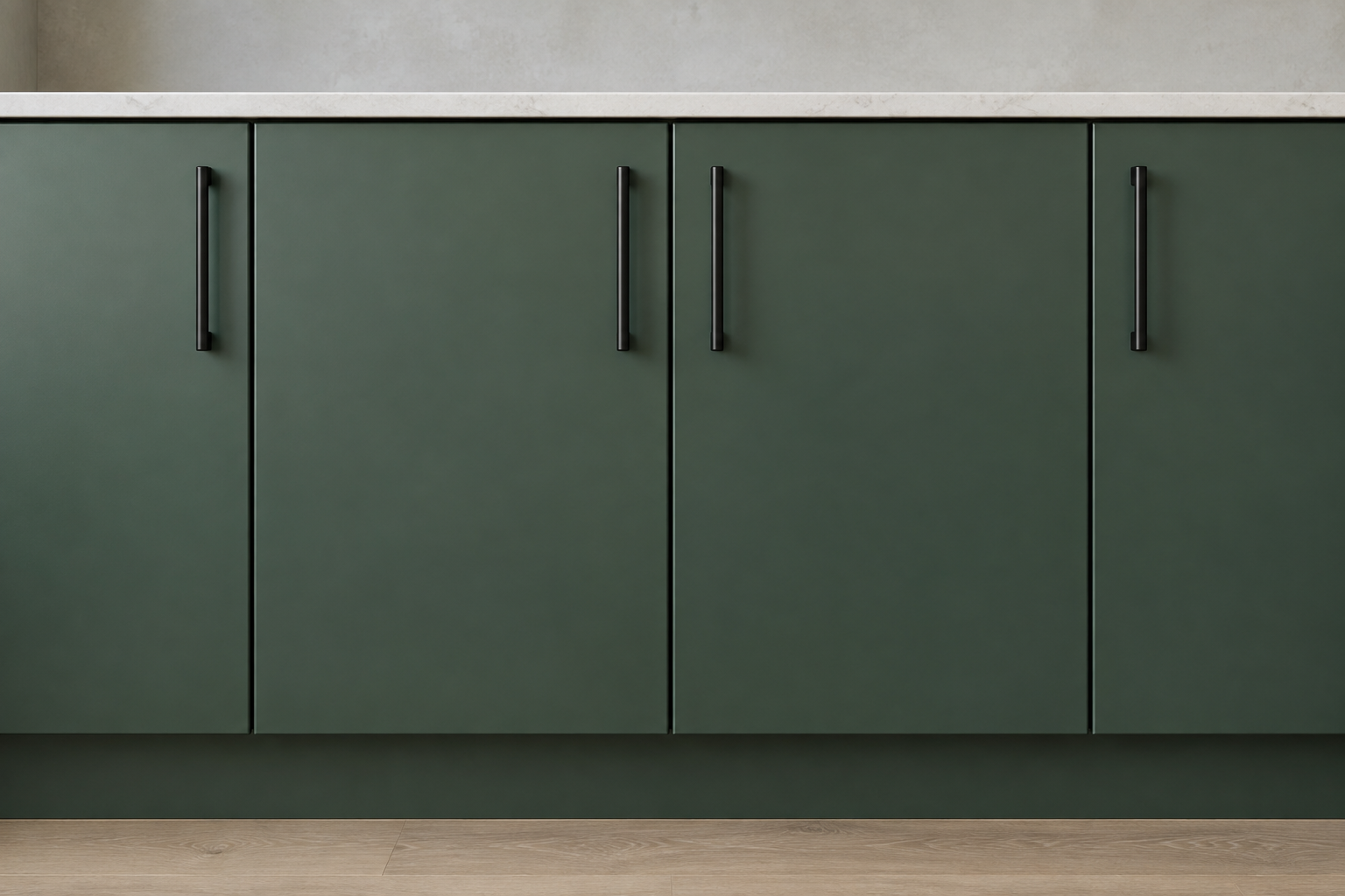 A close straight-on view of matte black bar-pull cabinet hardware on deep green slab-front kitchen cabinetry.