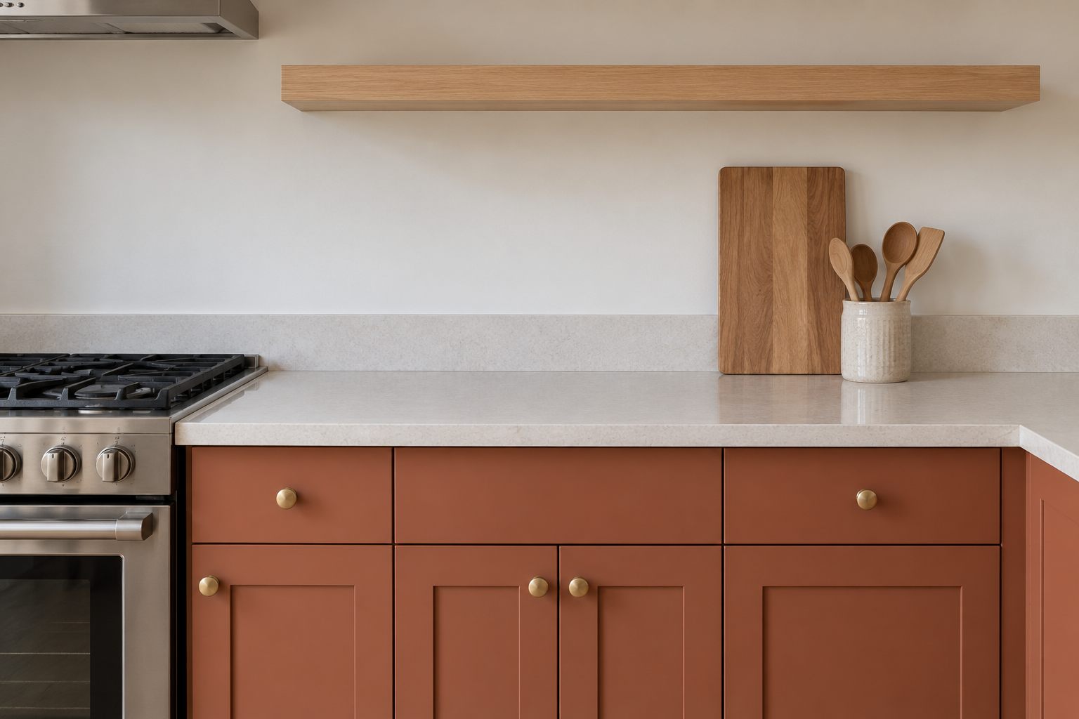 A cleared kitchen counter next to the stove holding only a cutting board and a small utensil crock.