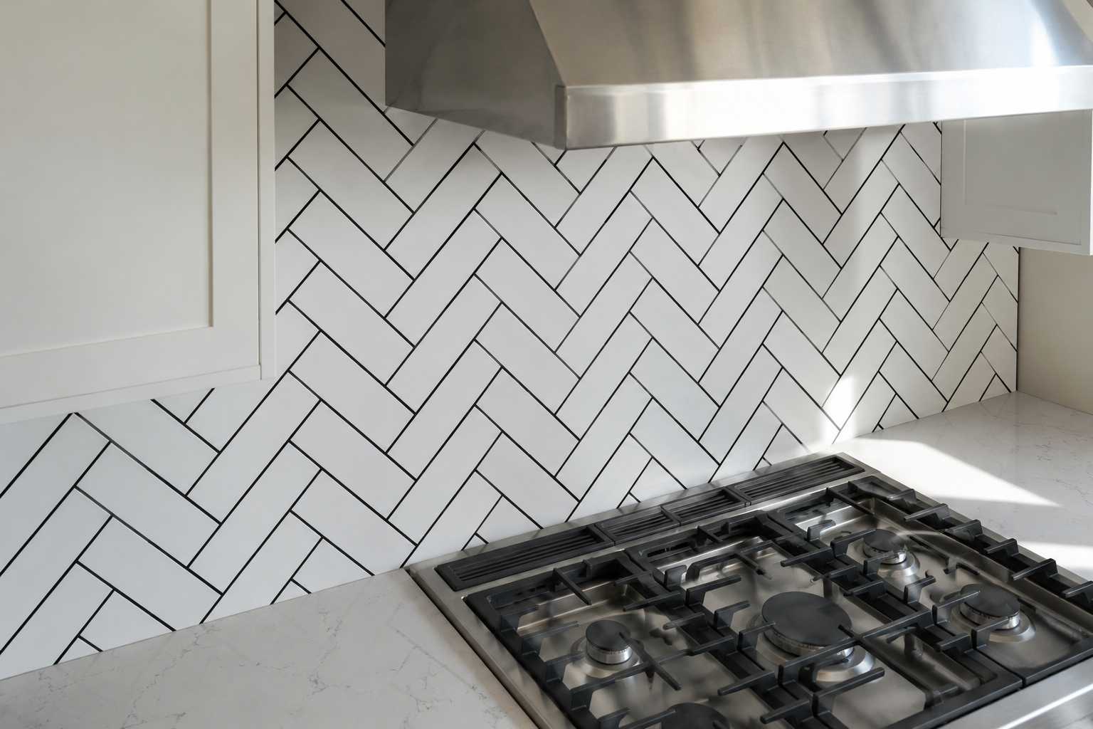 White herringbone tile with black grout making the pattern the wall's dominant feature.