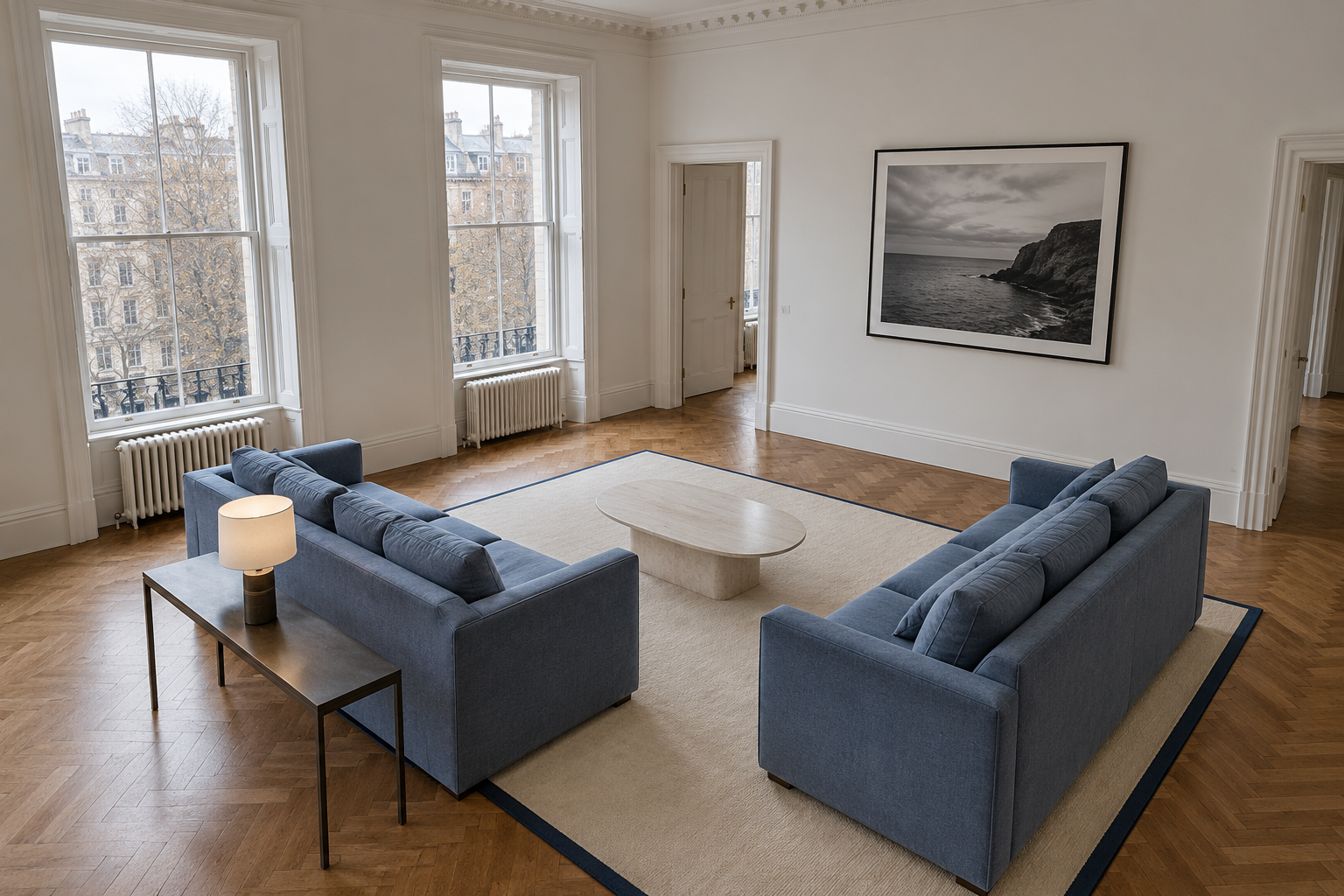 Two blue linen sofas facing each other close together in the middle of a large living room.