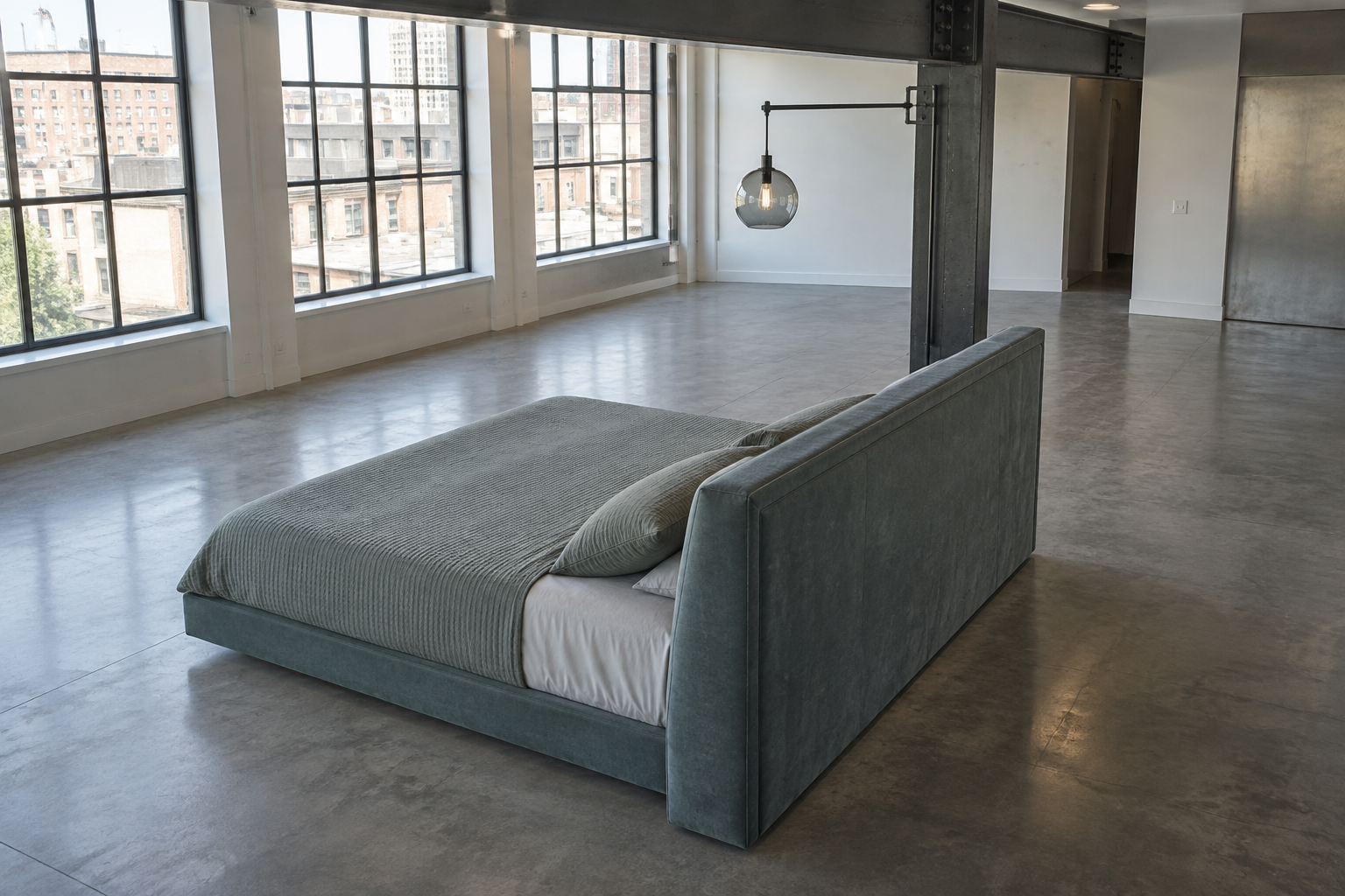 A low platform bed floated away from any wall in an open-plan loft bedroom, with open floor space visible on three sides.