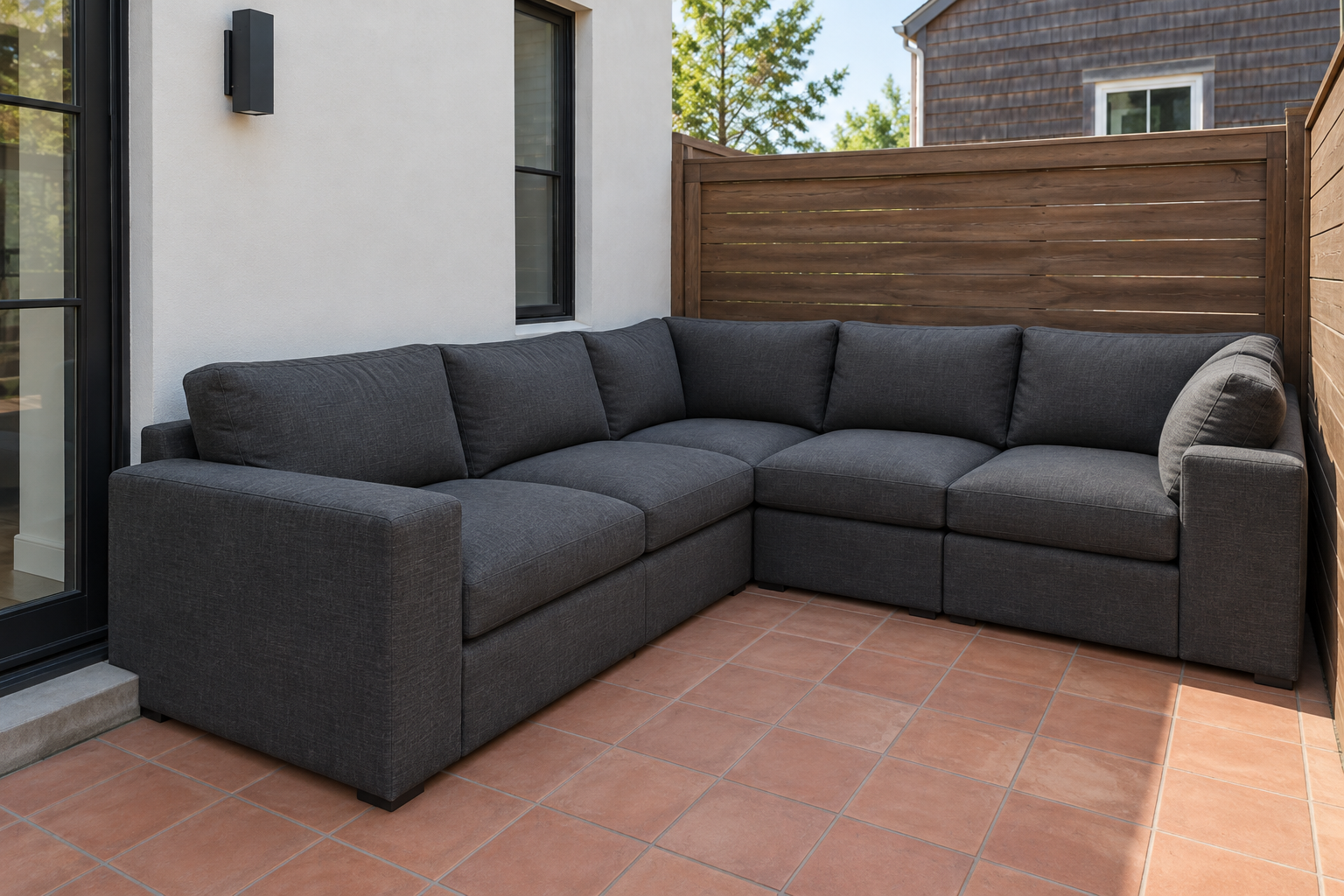 A bulky outdoor sectional crowded into a small paved corner, leaving almost no room to walk.