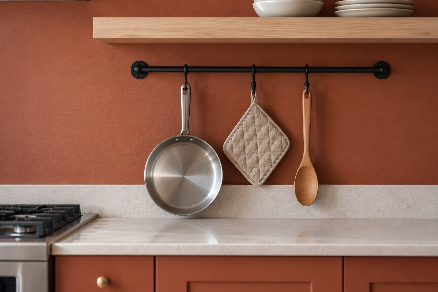 A matte black wall-mounted rail holding pans and utensils above a small kitchen counter.