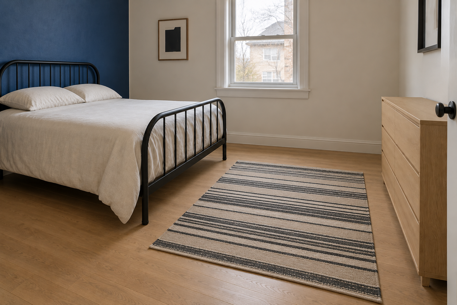 The same small secondary bedroom with the rug moved to the center of the floor, not touching the black iron bed frame, with visible bare floor on every side of the rug.