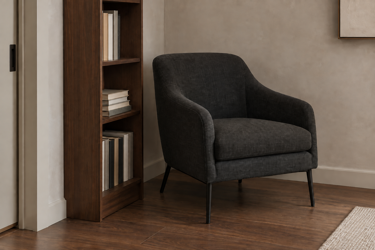 A narrow armchair and slim bookshelf claiming an awkward corner in a small living room.