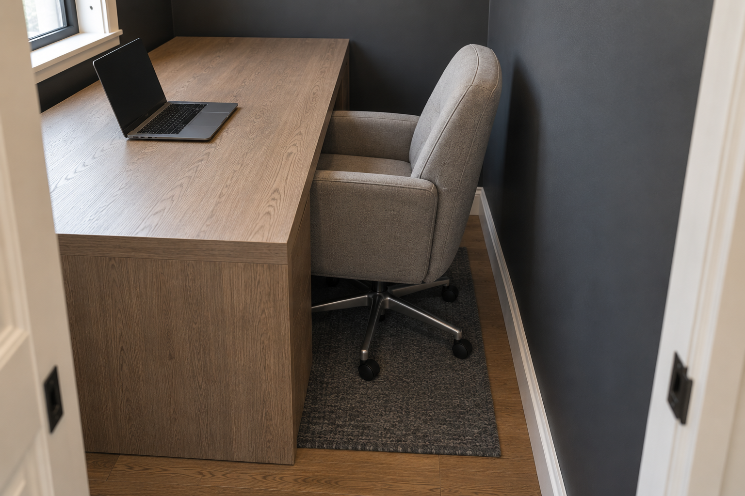 A desk too large for its small nook, with the chair blocked against the wall behind it.