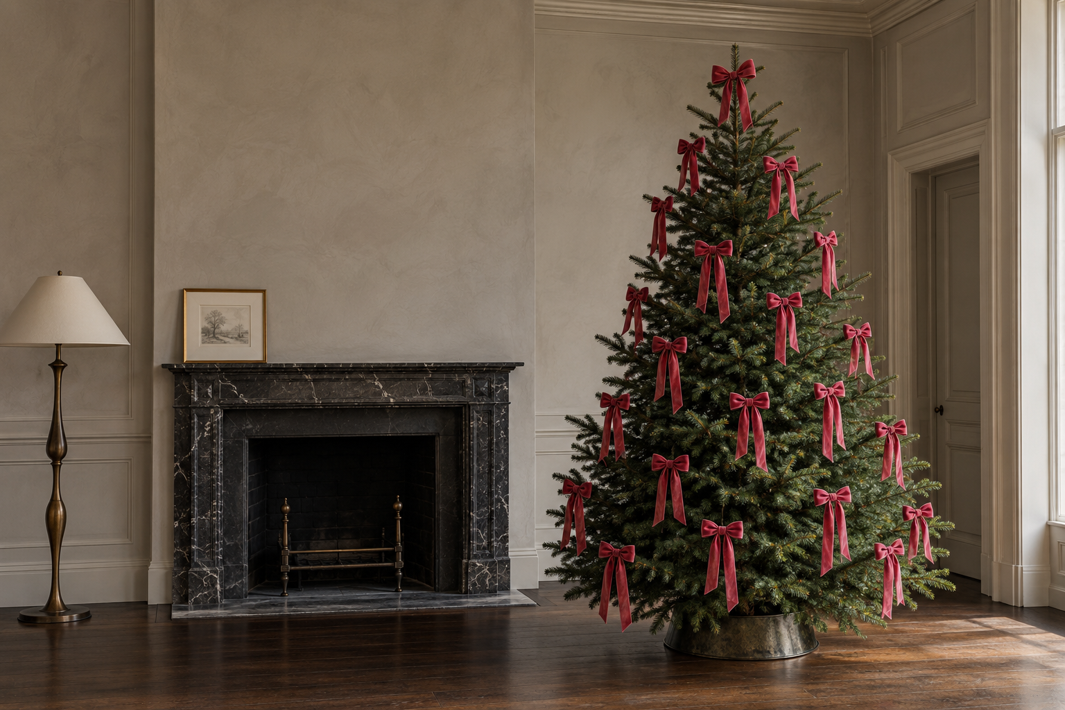 A Christmas tree decorated only with raspberry velvet bows beside a black marble fireplace in a room with warm gray plaster walls.