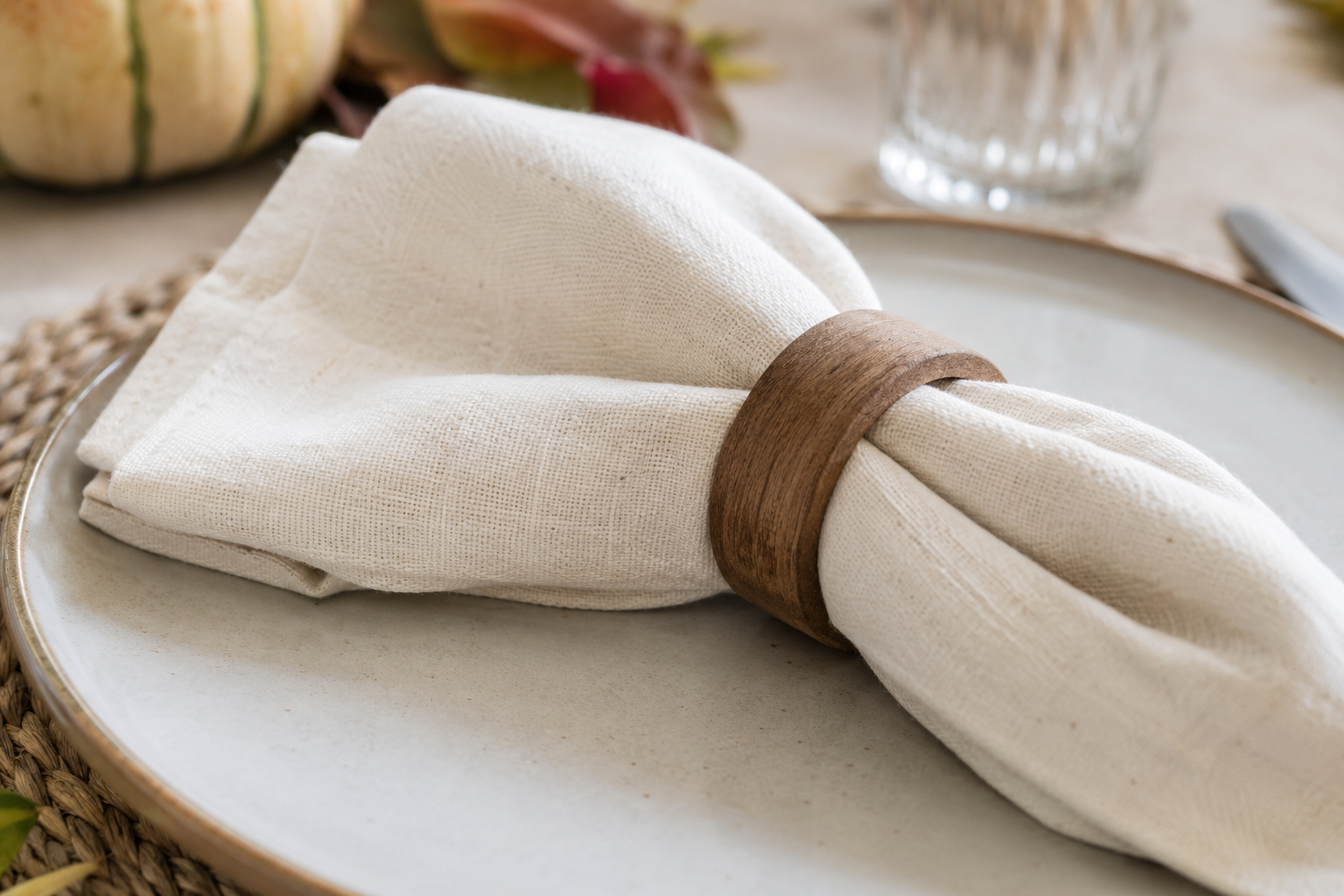 Folded cloth napkins with simple rings at a Thanksgiving place setting