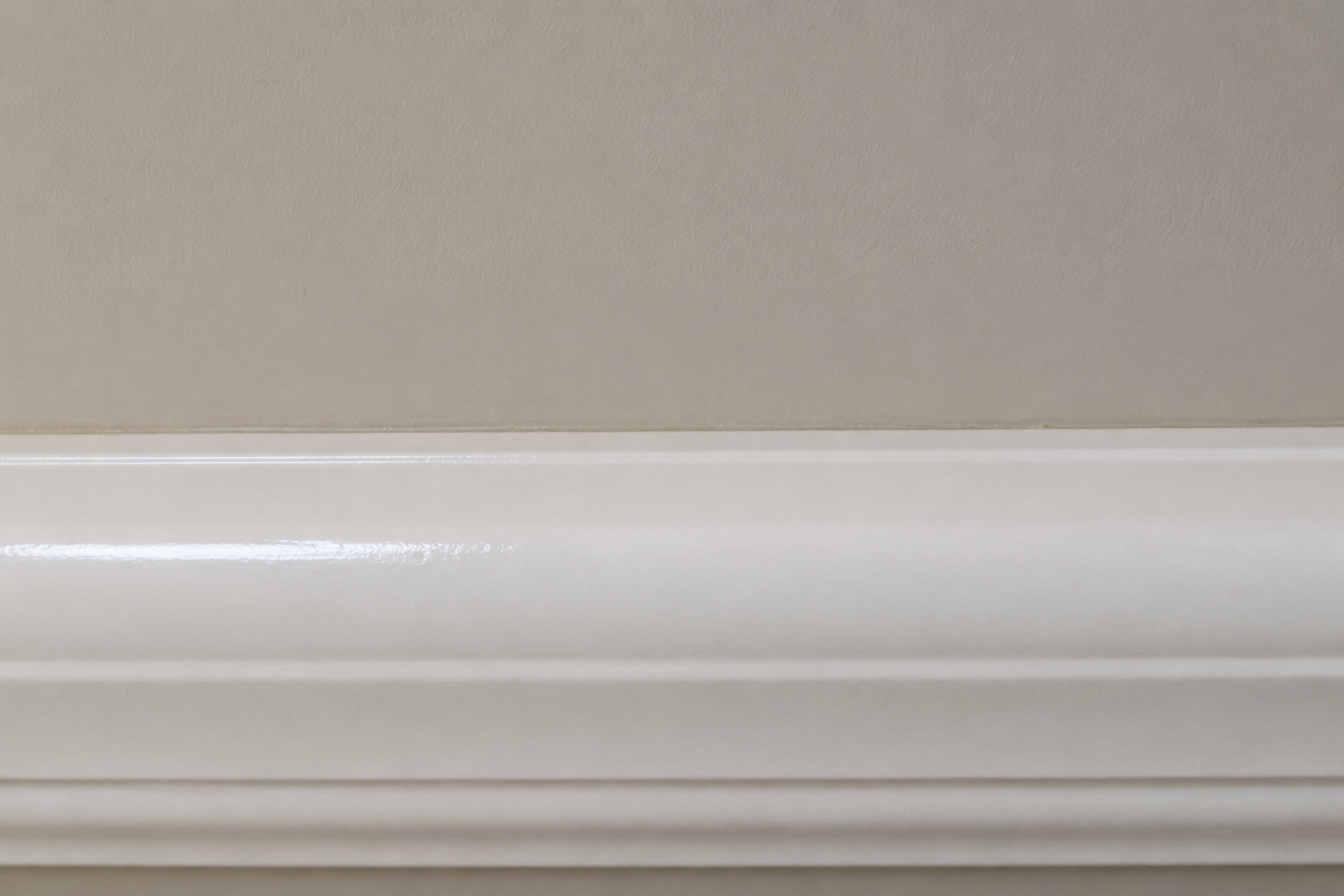Wall and trim painted in two different sheens meeting at the same edge