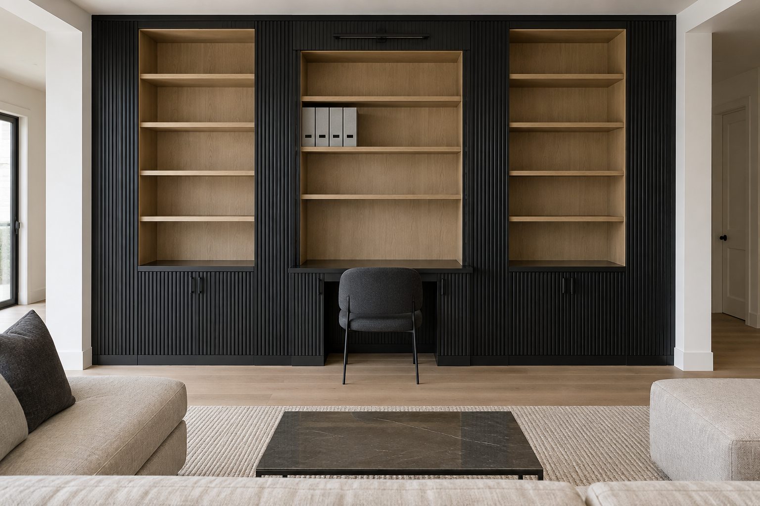 A full-height fluted black millwork wall in a living room with a desk built into its center, flanked by symmetrical shelving.