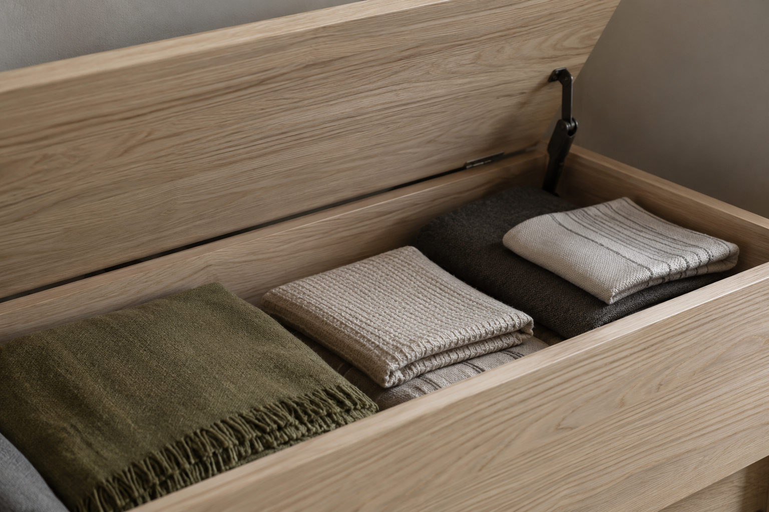 A storage bench near the seating area of a studio apartment, holding items specific to that zone.