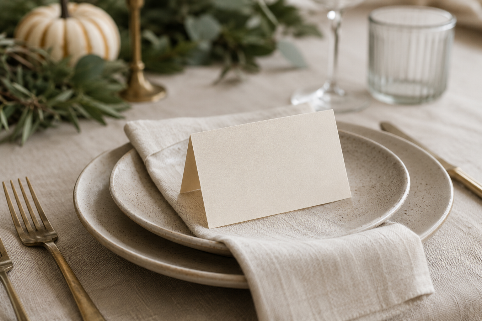 A simple folded place card as the only extra decorative detail at a Thanksgiving setting, no legible writing visible
