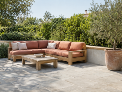 A mid-size patio with bluestone pavers, cedar furniture, and one warm cushion accent, styled as a considered outdoor room
