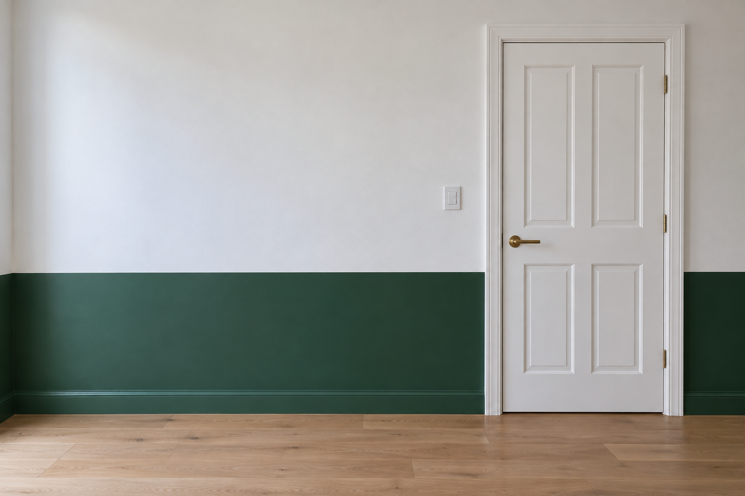 A hallway wall painted bottle green on its lower third and chalk white above, with the line between the two colors running past a white door.