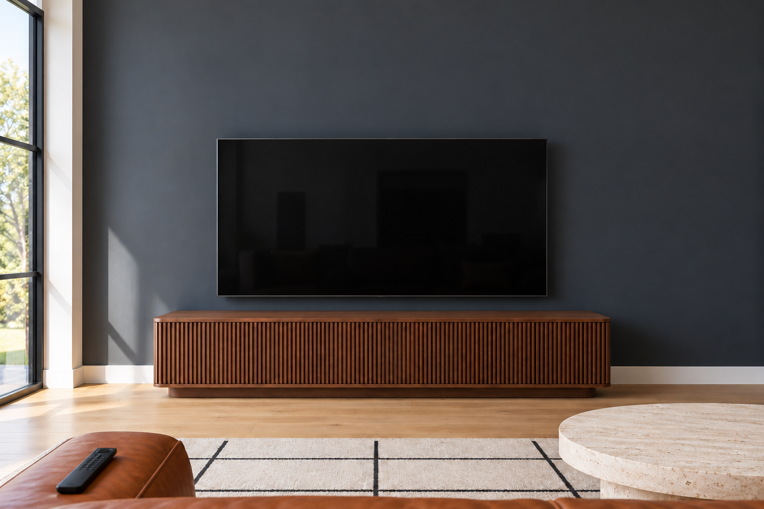 A view from a sofa toward a television mounted on a charcoal wall, with the middle of the screen straight ahead at seated eye level.