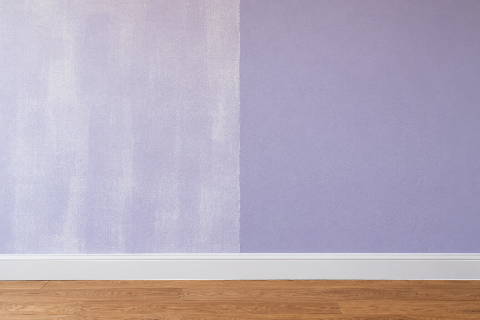 A wall painted lavender showing one coat on the left, with streaks of the old white showing through, beside an even second coat on the right.