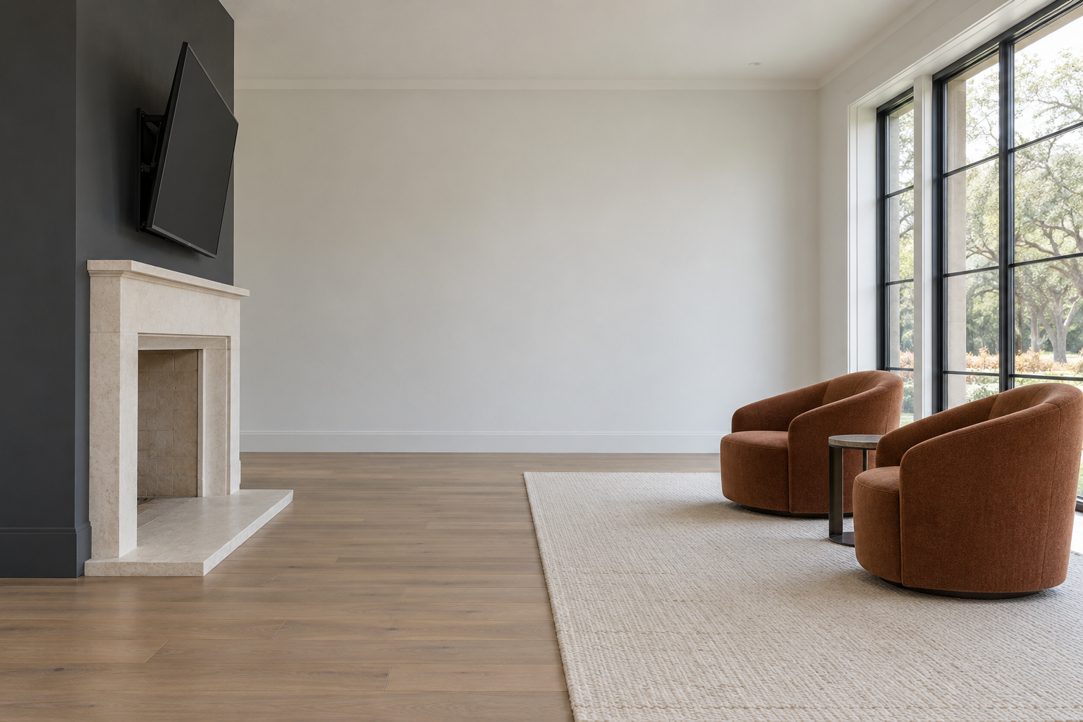 A television mounted above a limestone fireplace on a charcoal chimney breast, tilted downward, with two chairs set well back from it.