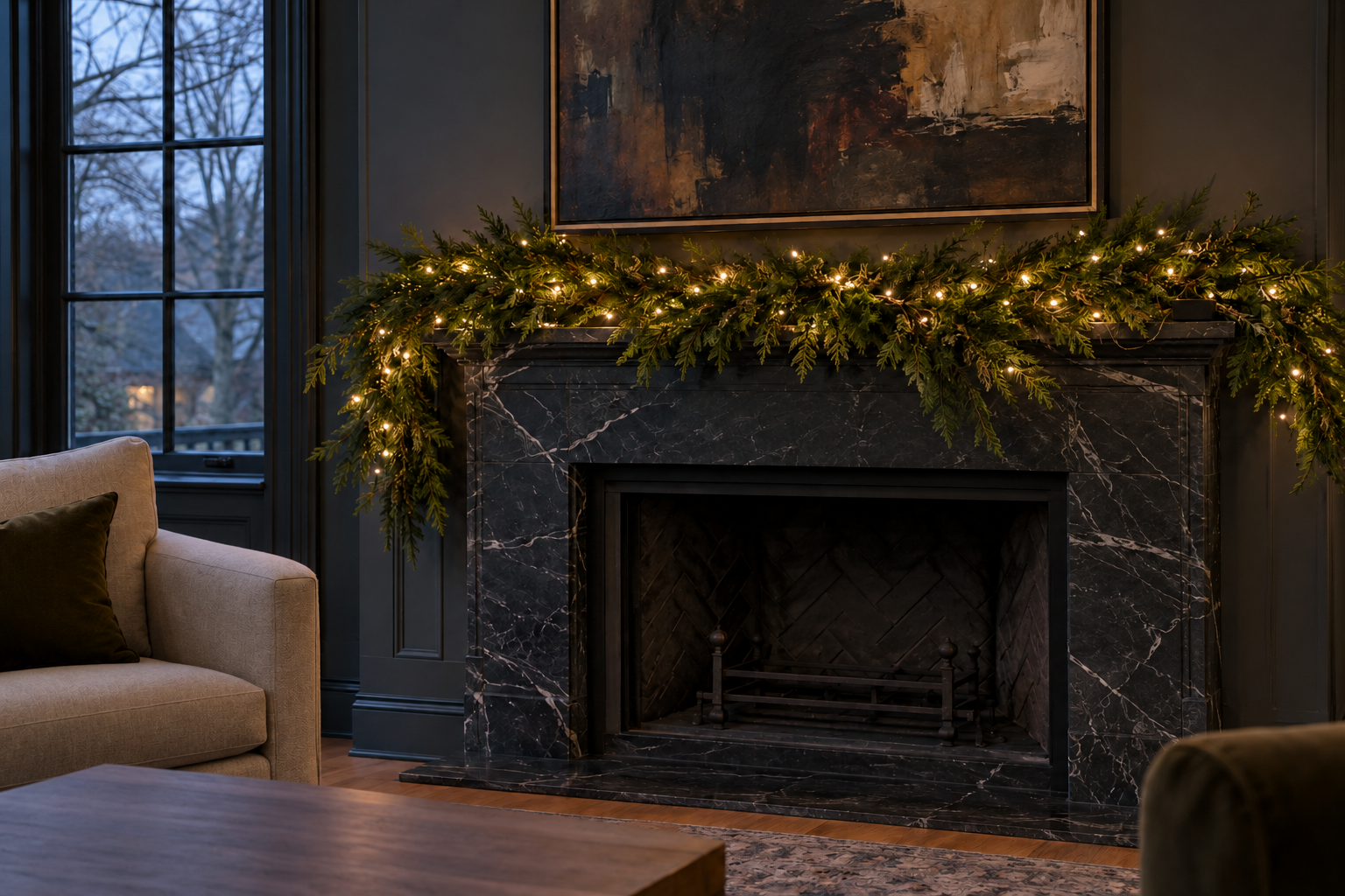 A garland on a black marble mantel at dusk, with small warm lights glowing at different depths among the branches.