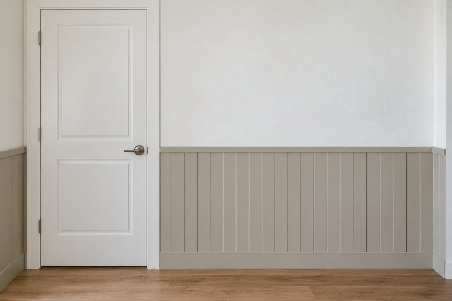 A hallway wall lined to hip height with vertical painted boards in putty gray below a white wall.