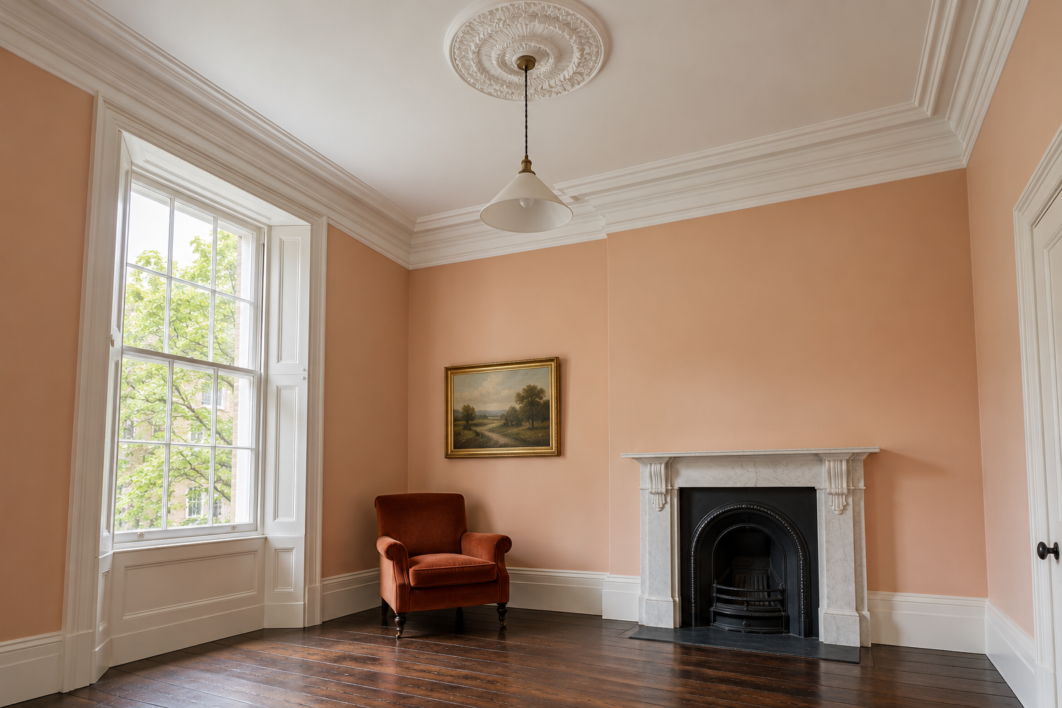 A Victorian sitting room with a deep white plaster cornice and a ceiling rose around a pendant, above pale apricot walls.