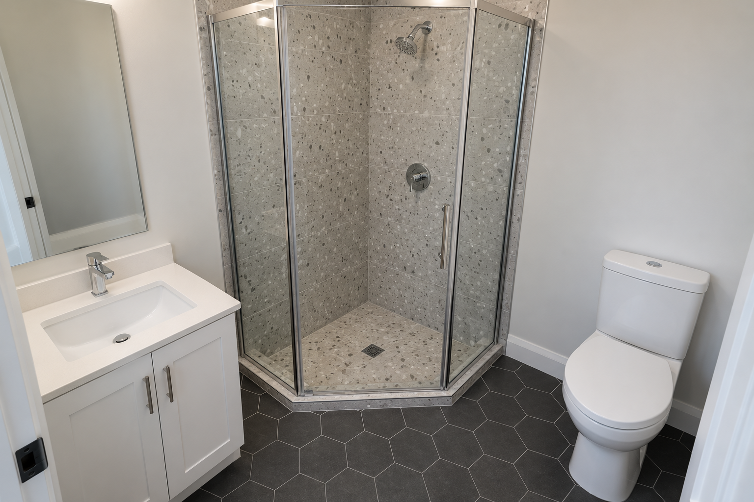 A glass corner shower with its front corner cut off at an angle, leaving a clear path past a small vanity.