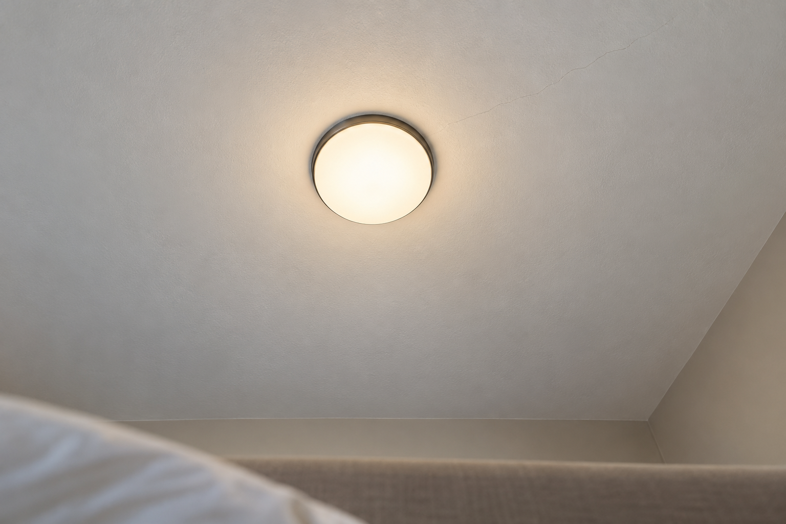 A round flush ceiling light with an opal glass diffuser seen from directly below, glowing evenly with no bulbs visible.