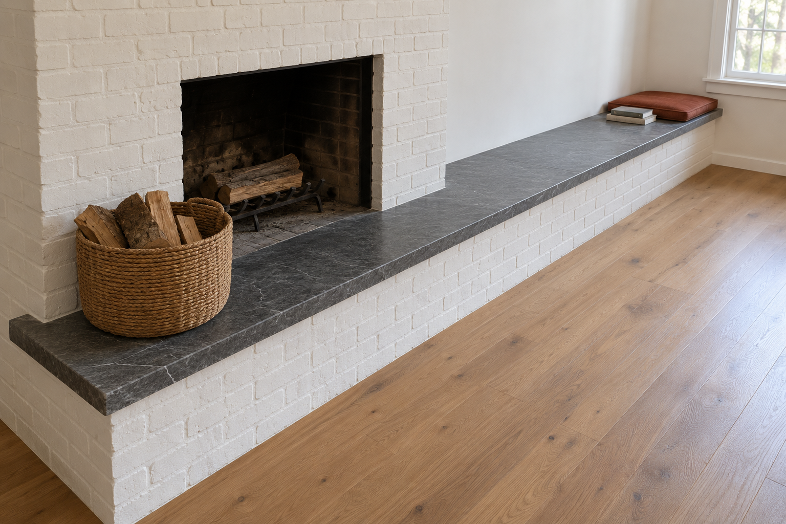 A raised soapstone hearth that continues along the wall as a long bench with a rust cushion at the far end.